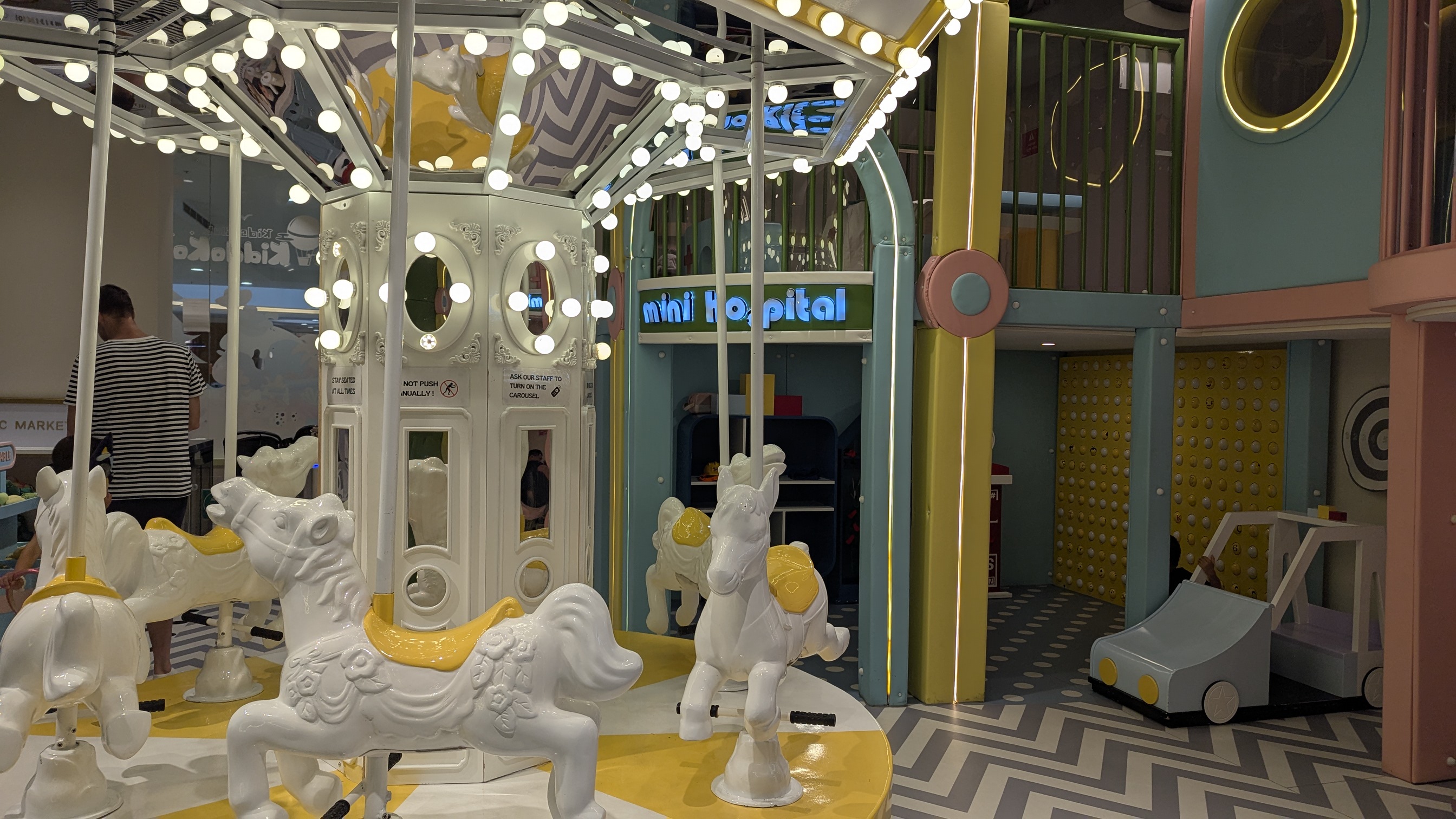 A small carousel with horses and bright lights.
