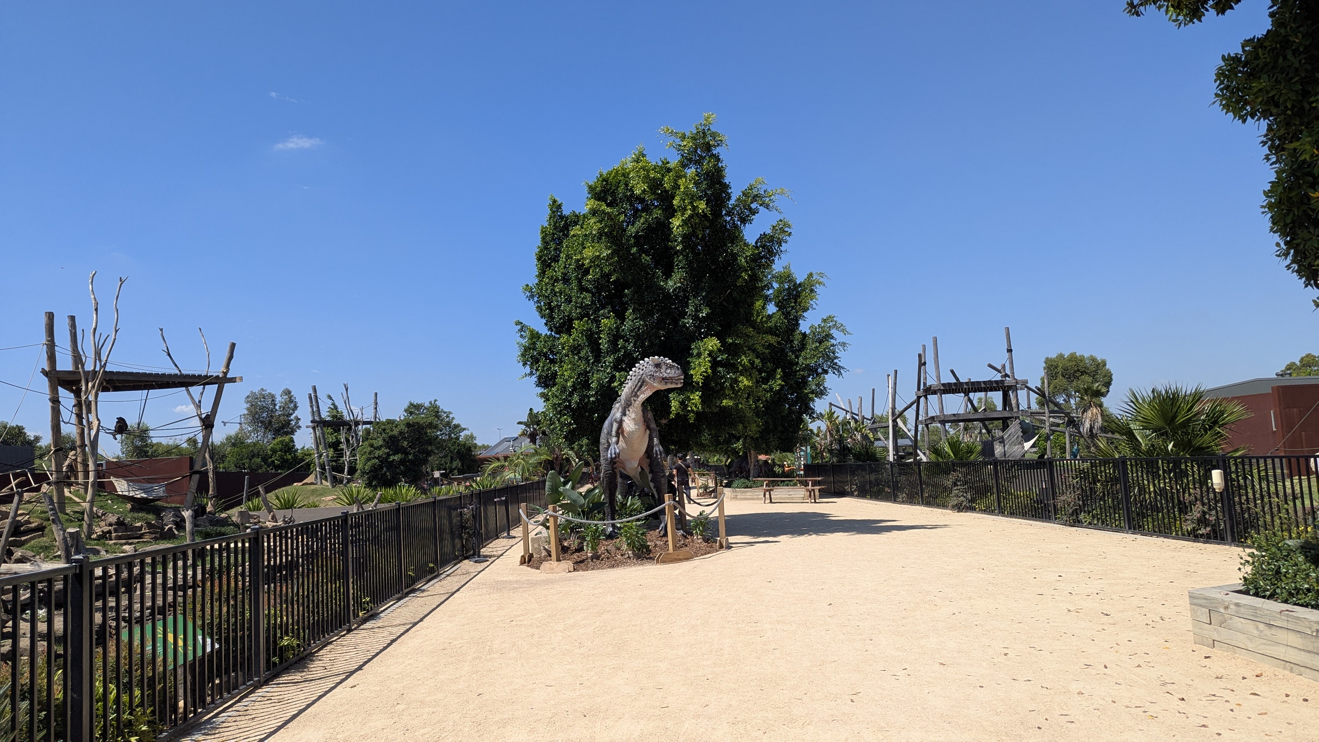 Wide dirt path with enclosures on either side.