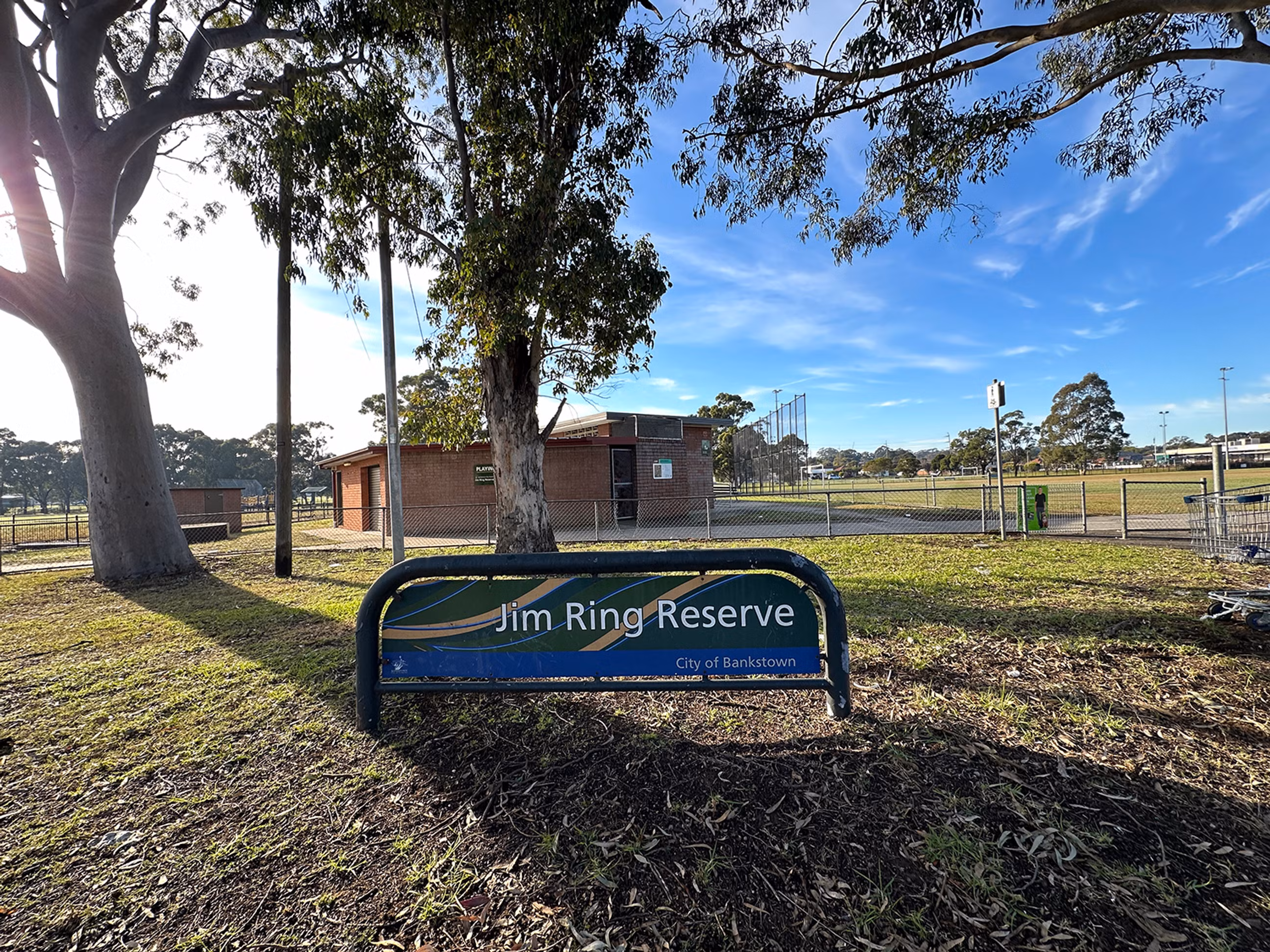 The entrance sign for Jim Ring Reserve with the club house in the background.