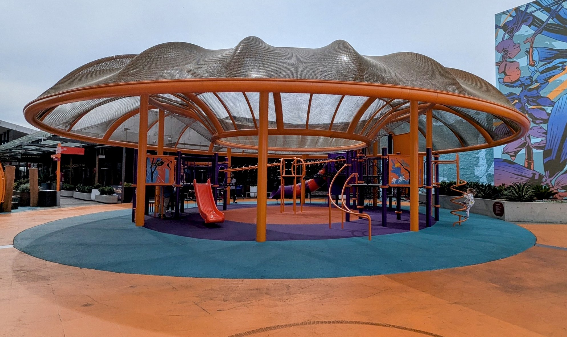 Small, bright playground with slides, climbing structures and net bridges.