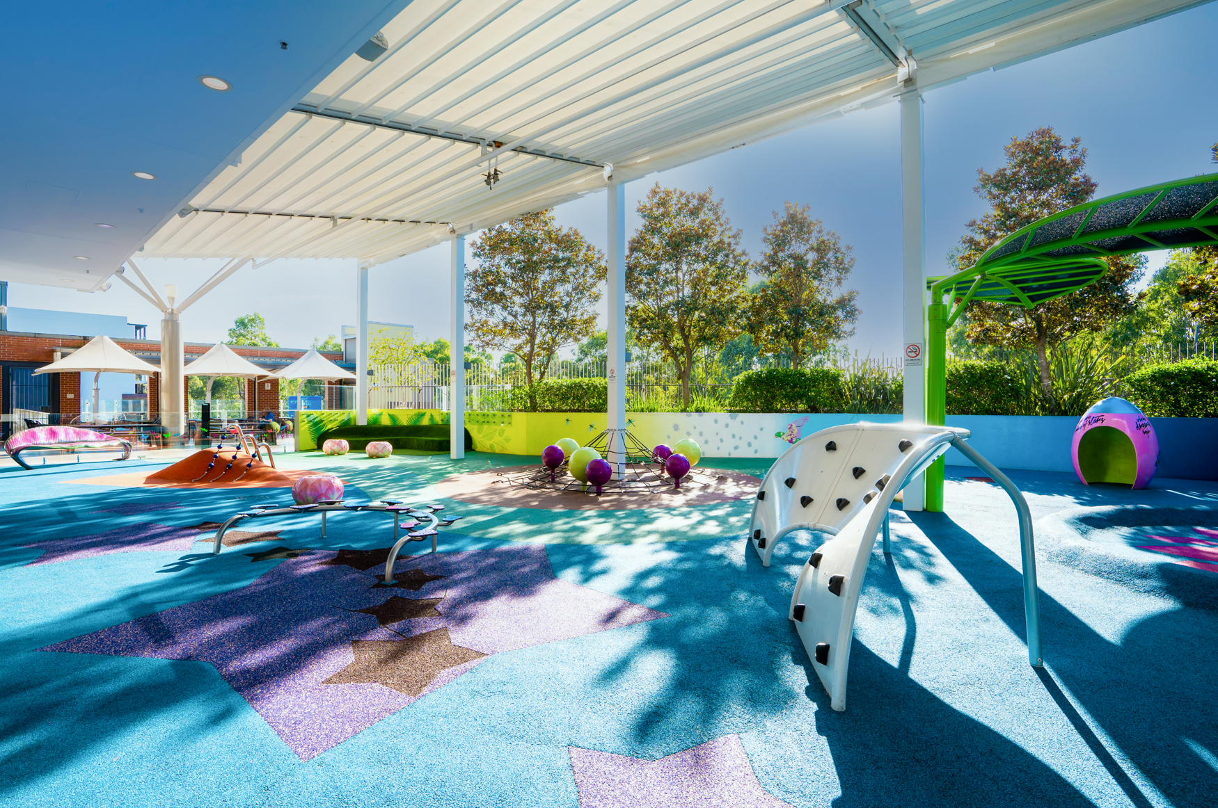 The undercover food terrace playground at Rouse Hill Town Centre with soft-fall flooring and play equipment.